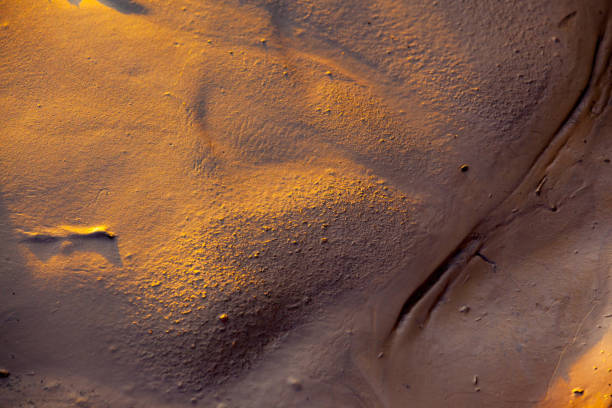 Abstract closeup of soft mud touched by golden light