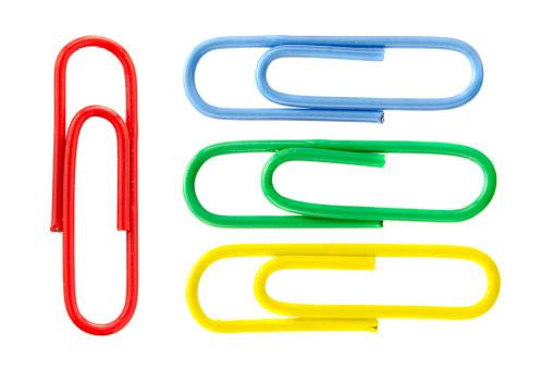 Collection of colorful paper clips isolated on white background, top view. Colored paper clips on a white background. Five colored paper clips isolated on a white background.