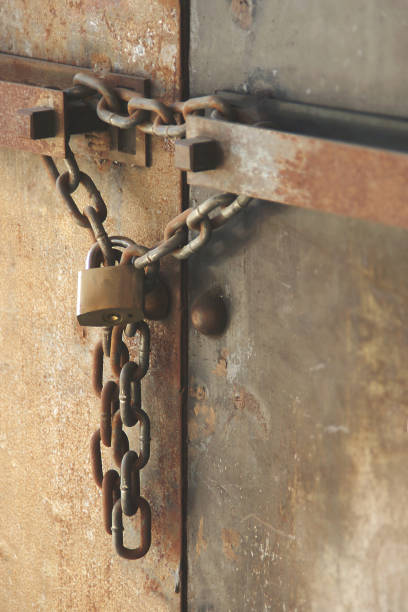 istock Rusty Chain with Lock on old Metal Double Doors 1278437339
