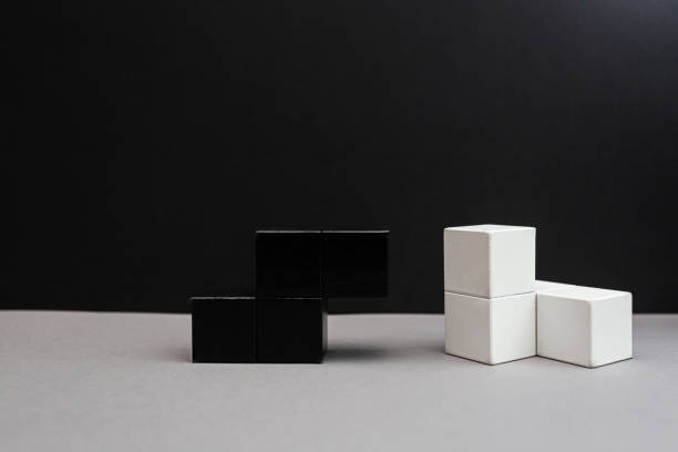 istock Black and white cubes on a gray-black background. Wooden puzzle. Logical thinking 1278438736