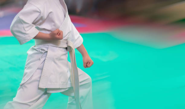 i bambini si allenano sul karate-do.  il combattente di karate si prepara a colpire con la mano. foto senza volti. - extreme sports karate sport exercising foto e immagini stock