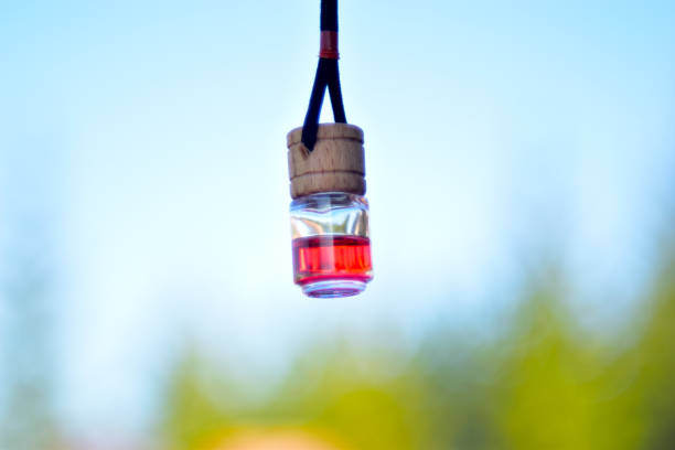una botella de perfume rojo para el coche en una cuerda - car freshner fotografías e imágenes de stock