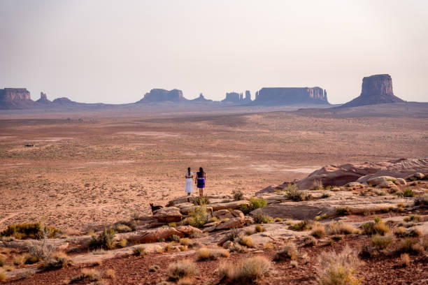 dos adolescentes navajo niñas nativas americanas mirando sobre el vasto desierto en el norte de arizona monument valley tribal park navajo reserva - navajo national monument fotografías e imágenes de stock