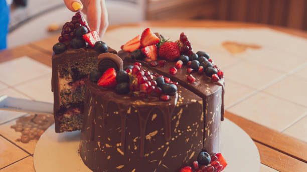 istock Appetizing chocolate cake decorated with strawberries, blueberries and a pomegranate on an orange background 1278443235