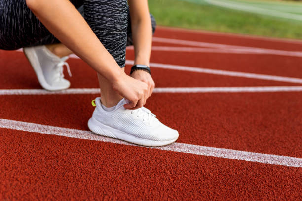 istock Female runner tying shoelaces on the running track 1278444758