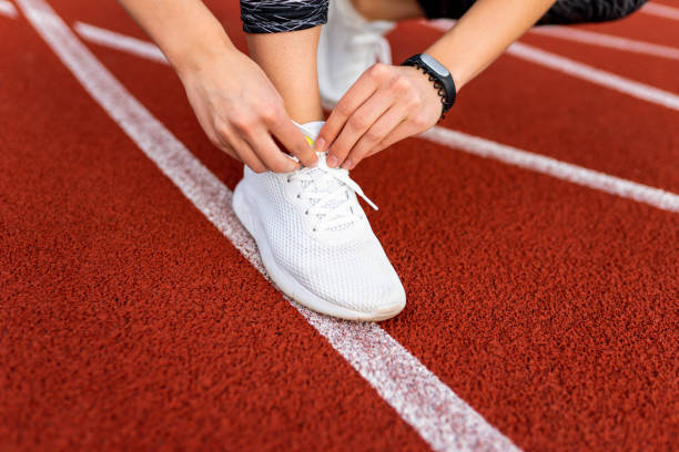 istock Female runner tying shoelaces on the running track 1278444759