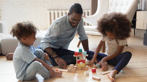 istock Smiling young african american father playing with children. 1278444907