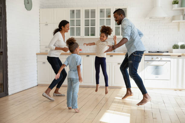 Overjoyed african american couple jumping with joyful energetic children. Full length overjoyed african american couple jumping with joyful energetic children siblings barefoot on warm kitchen floor, celebrating freedom weekend or enjoying stress free leisure active time. hot women working out pictures stock pictures, royalty-free photos & images