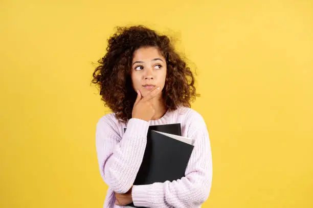 Photo of Young afro american woman on yellow copy space background