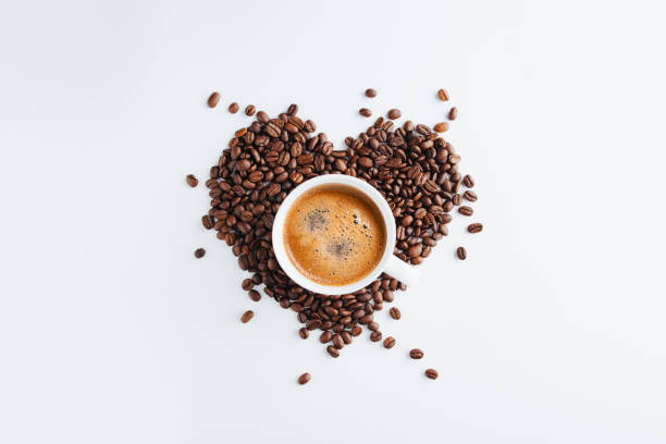 Cup of coffee Heart shape coffee beans Cup of coffee with roasted raw coffee beans making a heart shape cappuccino photos stock pictures, royalty-free photos & images