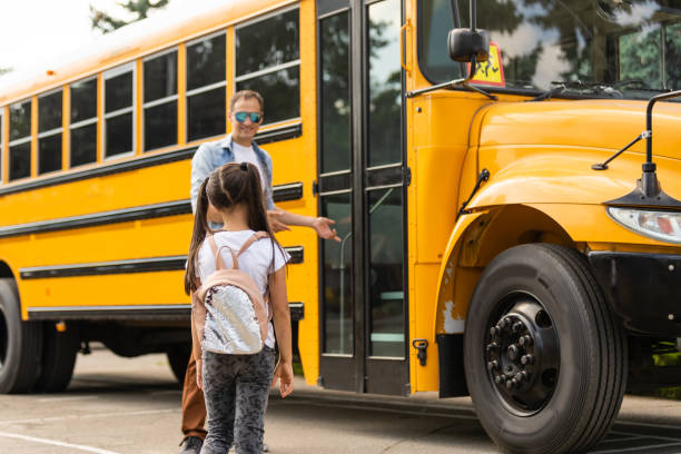 istock Smiling bus driver looking at camera outside the elementary school 1278447335