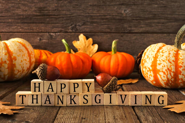 Happy Thanksgiving greeting against rustic wood with pumpkins and autumn leaves Happy Thanksgiving greeting on wooden blocks against a rustic wood background with pumpkins and autumn leaves thanksgiving stock pictures, royalty-free photos & images