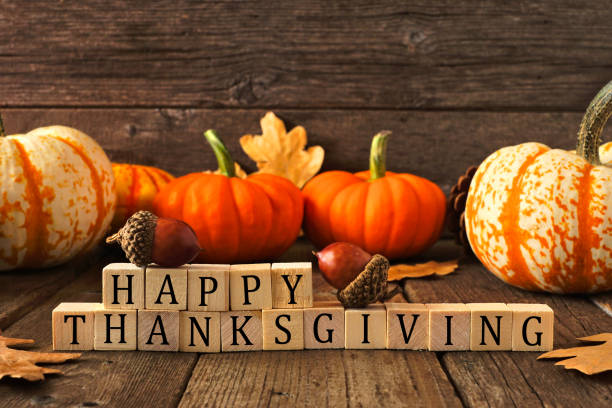 Happy Thanksgiving greeting against rustic wood with pumpkins and autumn leaves Happy Thanksgiving greeting on wooden blocks against a rustic wood background with pumpkins and autumn leaves physical description foods and drinks event household equipment stock pictures, royalty-free photos & images