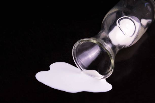 istock Spilled milk from a bottle on a black background.Copy space. 1278450252