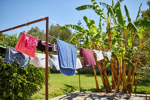 A clothesline draped with freshly washed laundry next to a banana tree in Spain. High resolution with copy space