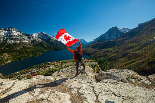 Parque Nacional De los Lagos de Waterton y hombre con bandera de Canadá photo