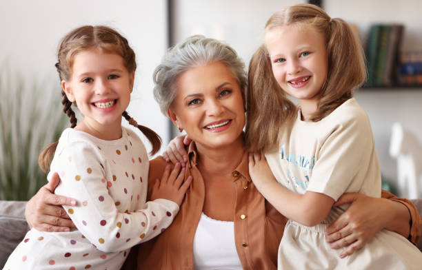 istock Happy grandmother and granddaughters on sofa 1278453328