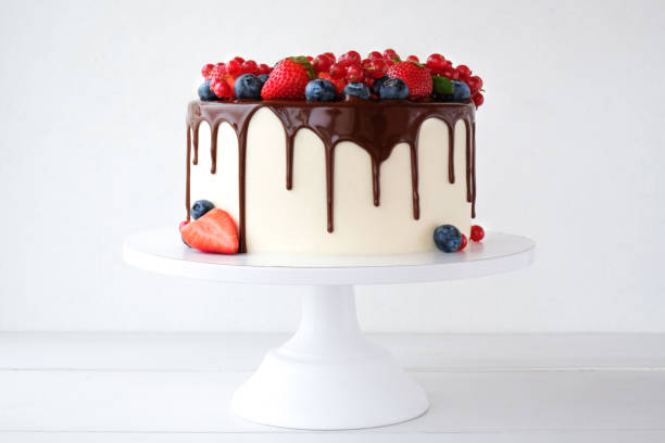 istock Cake with chocolate, decorated with various berries on a white table. Strawberries, blueberries, red currants. 1278453332