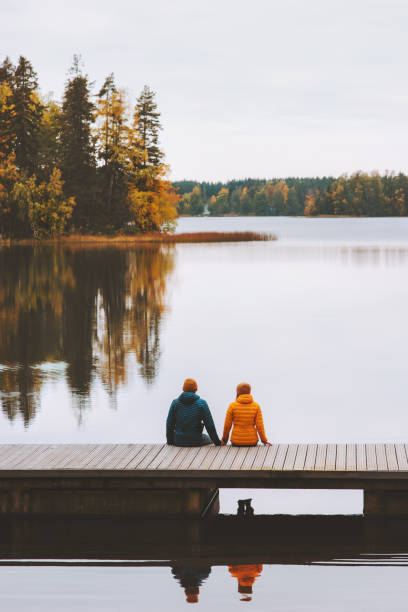핀란드 가족 생활 양식에서 여행하는 커플 은 부두 야외 호수와 숲 풍경 가을 시즌에 앉아 남자와 여자 친구 를 사랑 - valentines day romance boyfriend vertical 뉴스 사진 이미지