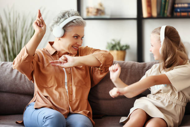 istock Grandmother and granddaughter dancing on sofa 1278456692