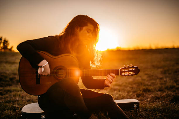 istock Young man playing guitar at sunset 1278456797