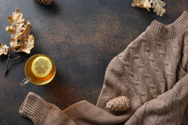 istock Warming tea with lemon in cozy sweater on brown. Top view with copy space. 1278458660