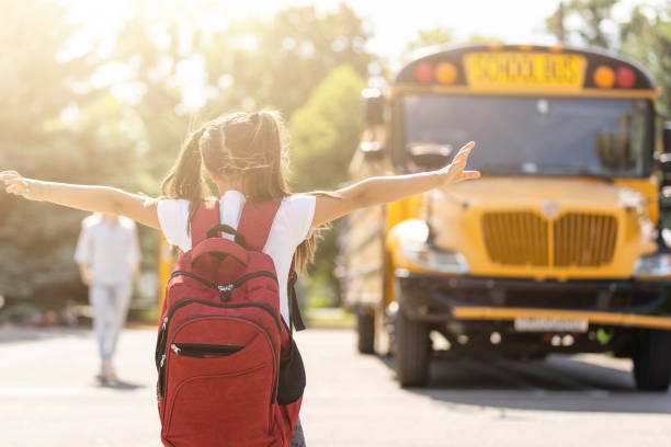 mutter bringt ihre tochter zur schule in der nähe des schulbusses. zurück zur schule - 5 month old stock-fotos und bilder