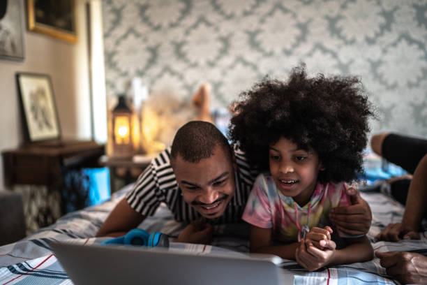 istock Father and daughter using laptop in bed 1278463821