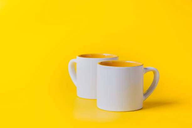 istock Empty coffee or tea white cup with yellow on yellow background. Copy space for text. 1278464699
