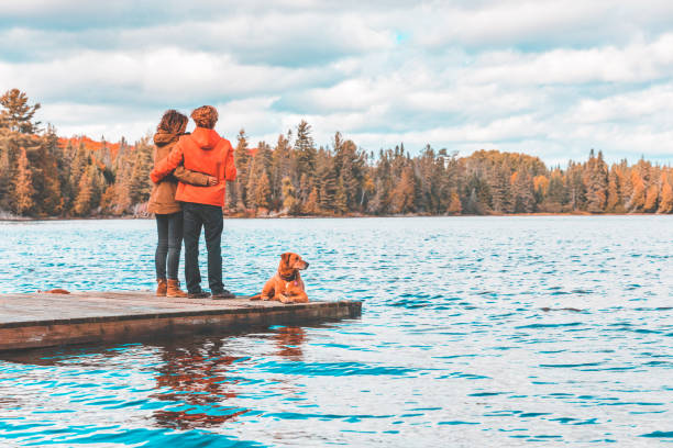 istock Couple on the dock with a dog, looking at view 1278468184