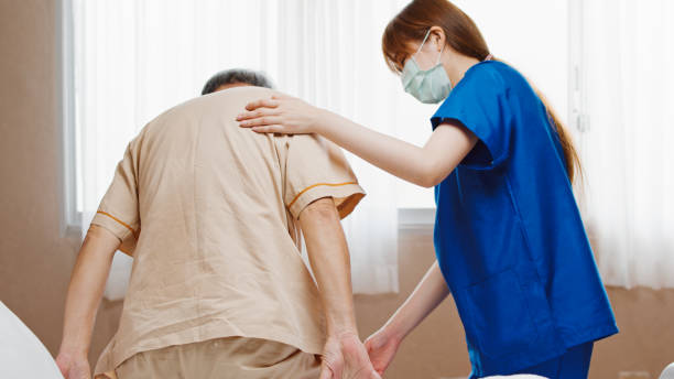 Female Asian nurse support senior male patient stand up and walk from bed in hospital. Nursing home, medical service, physiotherapy, hospitality, or recovery treatment concept Female Asian nurse support senior male patient stand up and walk from bed in hospital. Nursing home, medical service, physiotherapy, hospitality, or recovery treatment concept female nurse photos stock pictures, royalty-free photos & images