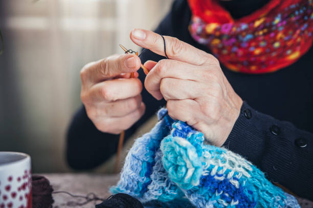 Senior old woman knitting a sweater, enjoying her free time, practicing her hobby Senior old woman knitting a sweater, enjoying her free time, practicing her hobby Crochet stock pictures, royalty-free photos & images