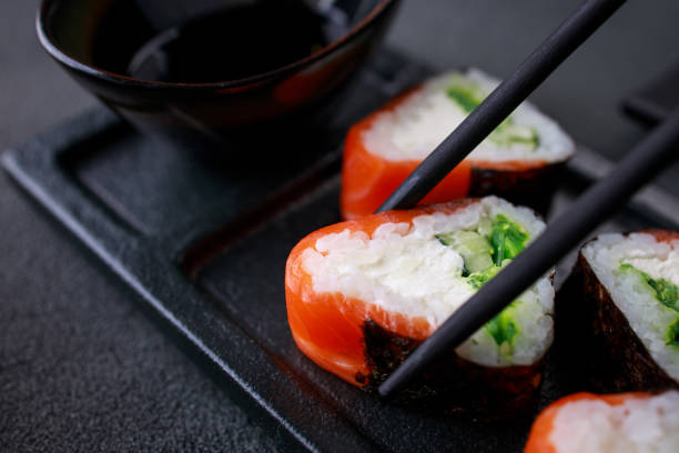 istock Chopsticks taking salmon maki roll from plate 1278475016