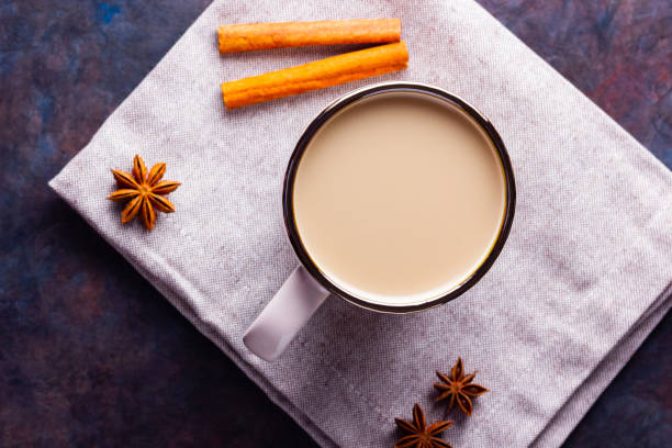 istock Masala chai tea. Traditional indian drink - masala tea with spices on black background. Ceramic cup of spices tea on linen napkin 1278476207