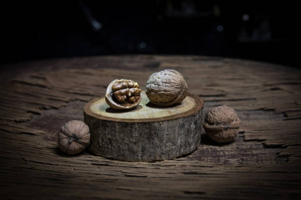 istock Still life with Walnut kernels and whole walnuts on rustic old wooden table. Creative table decoration. 1278477171