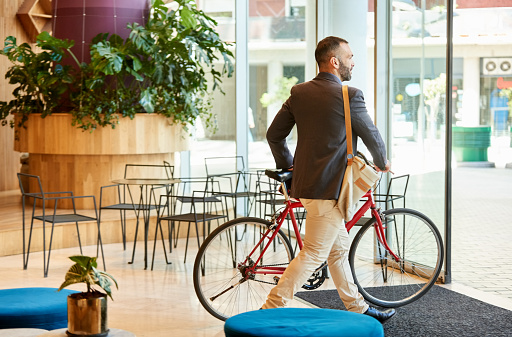 Shot of a businessman with his bicycle going home after work from office