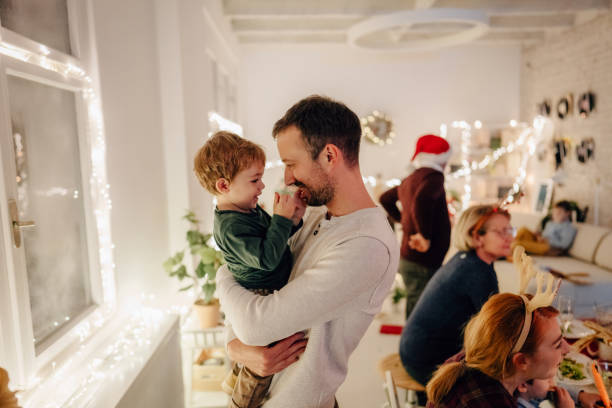 Photo of a father and son, sharing a moment, while celebrating Christmas Eve at home with family