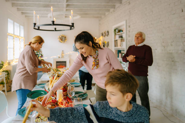 Family setting up the table for Christmas dinner