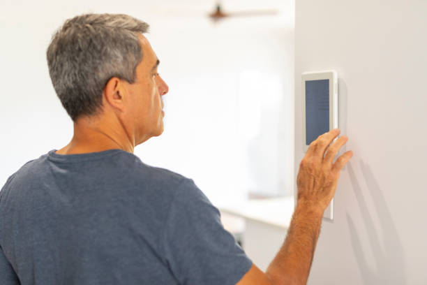 istock Middle Aged Man Using an Air Conditioner Thermostat 1278492046