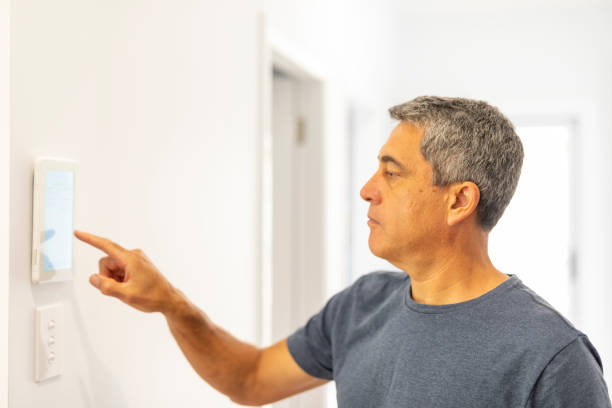 istock Middle Aged Man Using an Air Conditioner Thermostat 1278492051