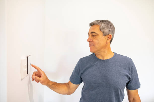 istock Middle Aged Man Using an Air Conditioner Thermostat 1278492054