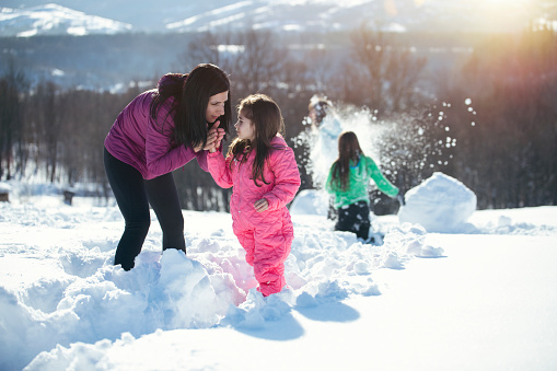 Young family are having fun outside at the snow