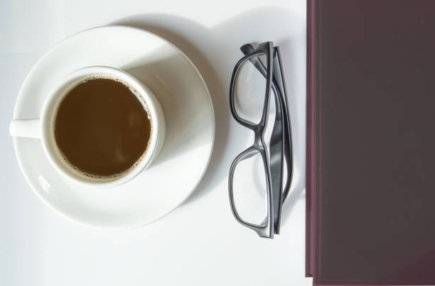 istock Top view, white coffee Cup, black men's glasses and brown diary, workplace 1278496291