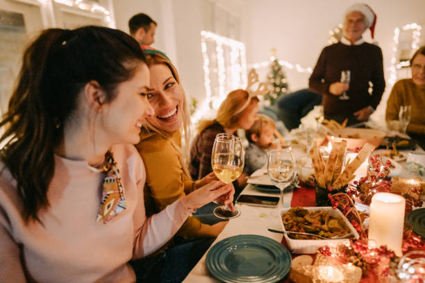 Multigenerational family celebrating Christmas at home Photo of a homosexual couple with their family during dinner, while celebrating Christmas Eve at home family christmas party stock pictures, royalty-free photos & images