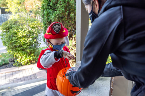 istock Young Boy wearing protective mask receiving candies on Halloween 1278500552