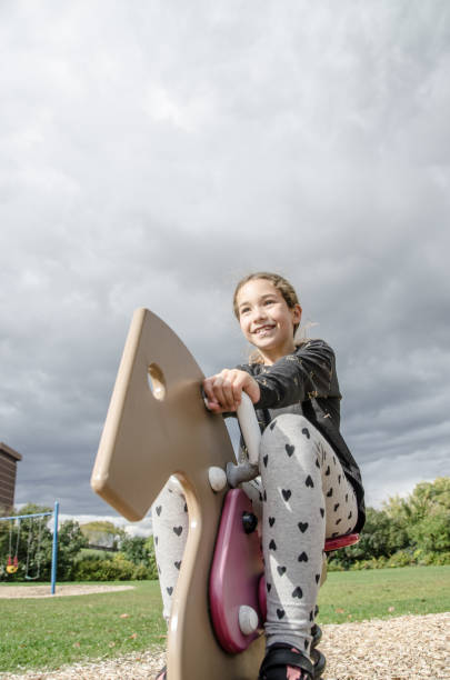 istock Girl playing on a horse swing 1278501099