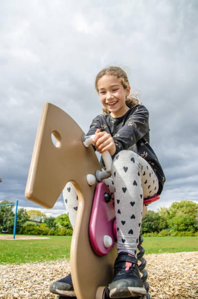 istock Girl playing on a horse swing 1278501136