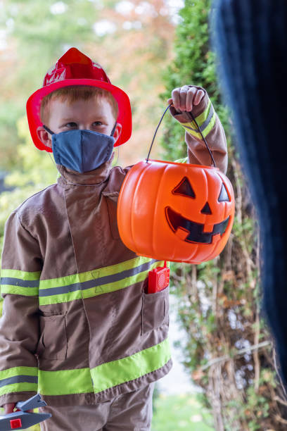 istock Young Boy wearing protective mask receiving candies on Halloween 1278501319