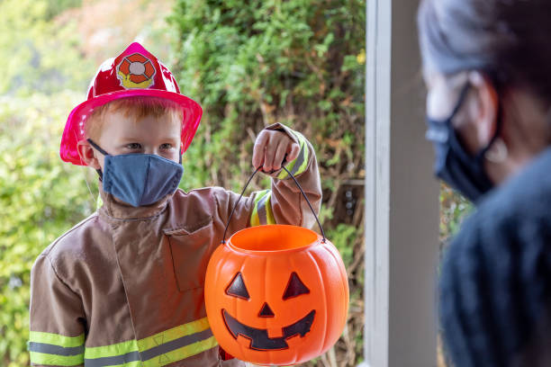 istock Young Boy wearing protective mask receiving candies on Halloween 1278501381