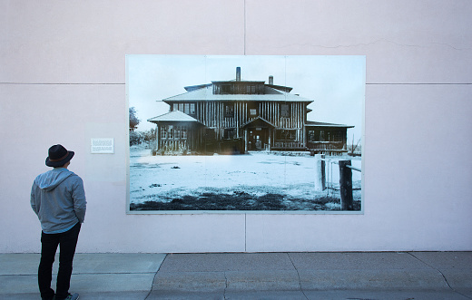 Los Alamos, NM: A man looks at a photo of the historic “Big House” in downtown Los Alamos, where the atomic bomb was developed under the aegis of the Manhattan Project in the 1940s. The Big House, which no longer exists, served as housing for visiting scientists in the 1940s.